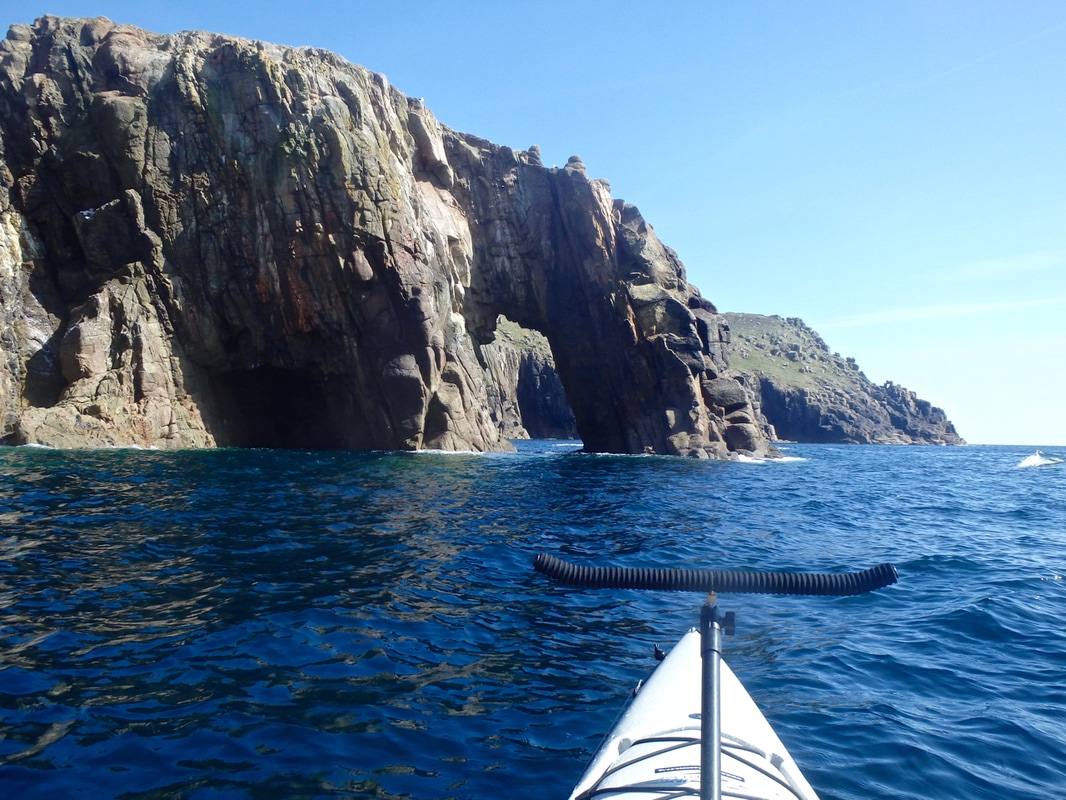 Kayaking through Enys Dodnan rock arch