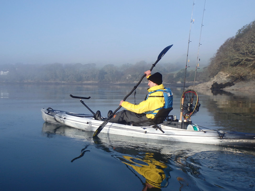 Paddling a fishing kayak on calm water RTM Rytmo