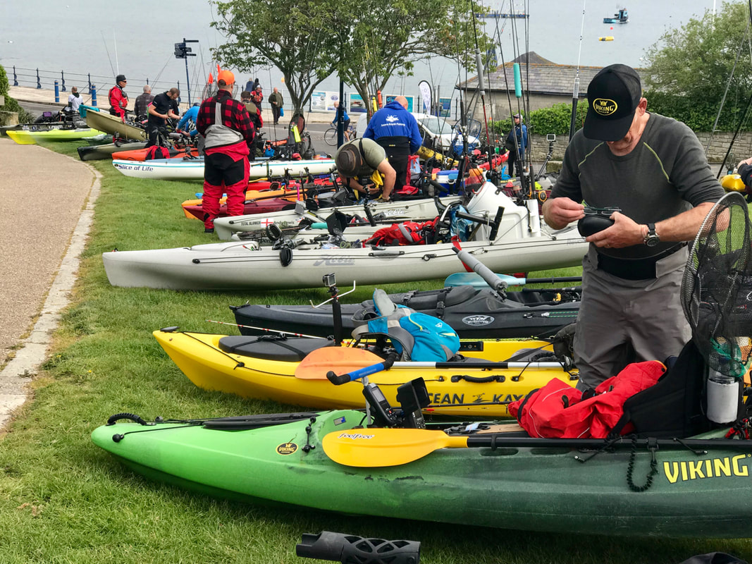 Kayaks anglers prepare for the competition at Swanage Bay UK